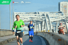 a group of people are running on a bridge with a sign that says vpbank on it