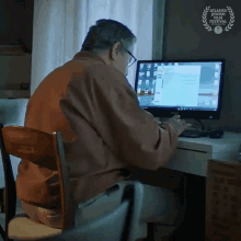 a man sits at a desk with a computer and a atlanta international film festival laurel on the bottom right