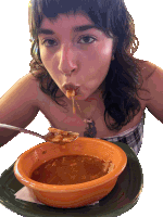 a woman with a tattoo on her chest is eating a bowl of soup with a spoon