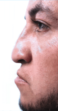 a close up of a man 's face with a white powder on his nose