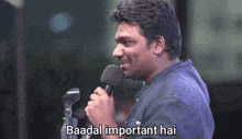 a man is speaking into a microphone with the words baadal important hai below him