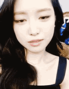 a close up of a woman 's face with long black hair