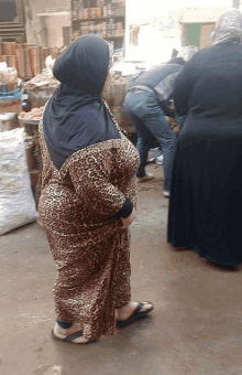 a woman in a leopard print dress is standing in a crowd of people