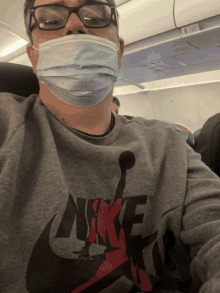 a man wearing a face mask and a grey nike shirt