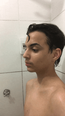 a man without a shirt is taking a selfie in the shower