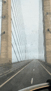 a view of a bridge from inside a car with a white line on the right