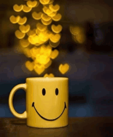 a yellow coffee mug with a smiley face on it is on a table .