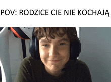 a young boy wearing headphones is smiling in a meme