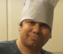 a man wearing a chef 's hat is smiling and looking at the camera .