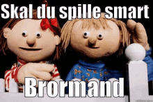 a couple of stuffed animals standing next to each other with the words skal du spille smart broormand below them .