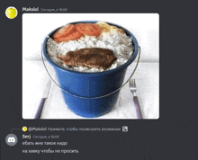 a blue bucket filled with rice and meat with a fork and knife on a table