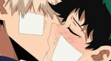 a couple of anime characters are kissing each other with a piece of paper on their faces .