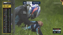 a man sits in the grass watching a race with a safety car