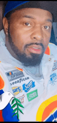 a man with a beard wearing a nascar cup series jacket