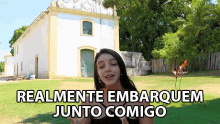 a woman stands in front of a white building with the words " realmente embarquem junto comigo " on the bottom