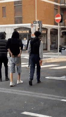 a group of people standing on a street in front of a building that says ' bar ' on it