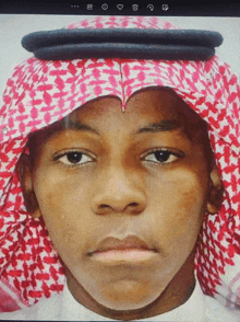 a close up of a person 's face with a red and white head scarf on