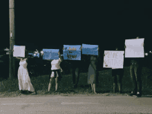 a group of people are holding up signs including one that says kenneth matthew