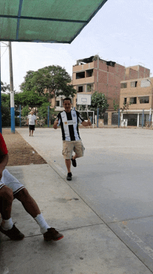 a man wearing a shirt that says ' alianza ' on it is running on a basketball court