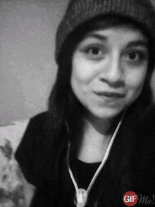 a black and white photo of a woman wearing a beanie and headphones with a gif me logo in the corner