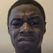 a close up of a man 's face making a sad face .