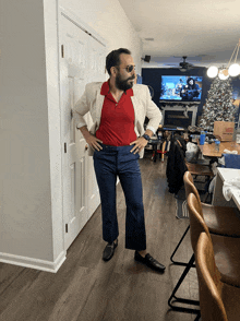 a man in a red shirt and blue pants is standing in a living room