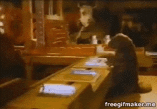 a gif of a person sitting at a table with the words freegifmaker.me below it