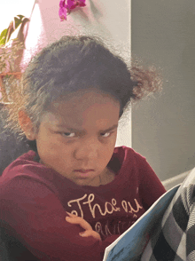 a little girl wearing a red shirt that says " there "