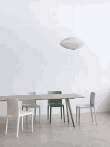 a dining room table and chairs with a pendant light hanging from the ceiling