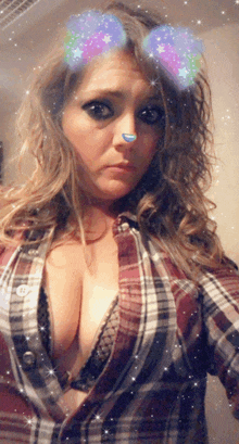 a woman wearing a plaid shirt and a bra is taking a selfie