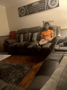 a man is sitting on a couch in a living room .