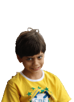 a young boy wears a yellow shirt with the word cre on it