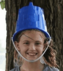 a young girl wearing a blue bucket on top of her head