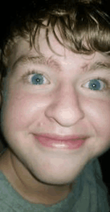 a close up of a young man 's face with blue eyes and red cheeks .