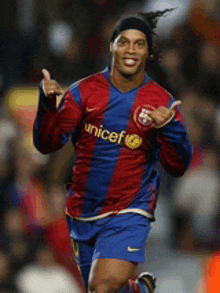 a soccer player wearing a shirt that says unicef giving a thumbs up