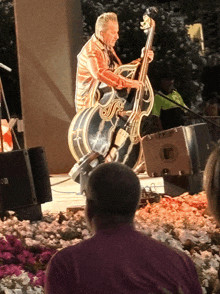 a man playing a double bass in front of a speaker that says sr