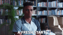 a man sitting in front of a bookshelf with the words " a fresh start " in front of him