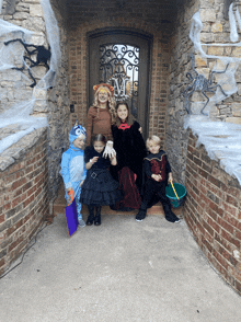 a group of children in halloween costumes pose in front of a door with the letters m on it