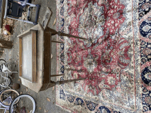 a table sits on top of a rug with a bicycle in the background