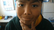 a young boy is making a funny face in front of a clock that shows the time as 10:10