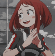 a girl with red hair is smiling with her hands folded in front of her face