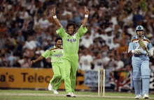 a man wearing a green pakistan jersey celebrates