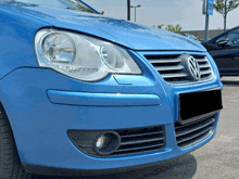 a blue volkswagen car is parked in a parking lot with a black license plate