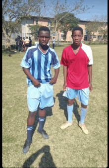 a man in a blue and white striped shirt stands next to a man in a red and white shirt