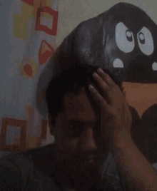 a man covering his face with his hands in front of a cartoon character