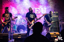 a band playing in front of a sign that says " bad crew " on it