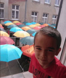 a young boy wearing a red shirt with the word lgua on it