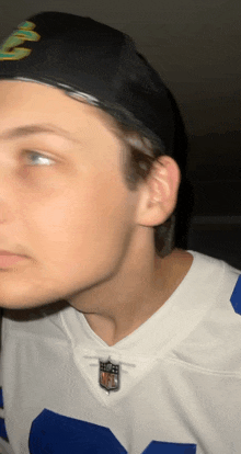 a young man wearing a cowboys jersey and a nike hat