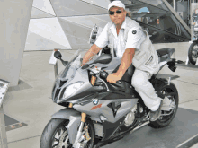 a man sitting on a bmw motorcycle wearing a nike hat