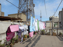 clothes hanging on a clothes line with a pink backpack on top